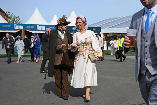 Racegoers arrive in the sunshine on Ladies Day, day two of the Grand National Festival horse race meeting at Aintree Racecourse in Liverpool, north-west England, on April 10, 2026. (Photo by Paul ELLIS / AFP)