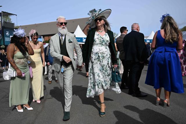 Racegoers arrive in the sunshine on Ladies Day, day two of the Grand National Festival horse race meeting at Aintree Racecourse in Liverpool, north-west England, on April 10, 2026. (Photo by Paul ELLIS / AFP)