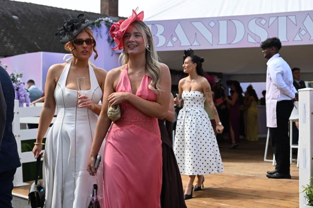 Racegoers arrive in the sunshine on Ladies Day, day two of the Grand National Festival horse race meeting at Aintree Racecourse in Liverpool, north-west England, on April 10, 2026. (Photo by Paul ELLIS / AFP)