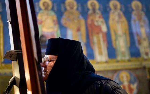 East-Orthodox nun prays to a wooden crucifix during the Good Friday service in St Nedelya Church in Sofia on April 10, 2026. (Photo by Nikolay DOYCHINOV / AFP)