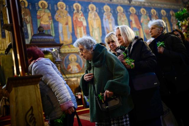 East-Orthodox believers pray to a wooden crucifix during the Good Friday service in St Nedelya Church in Sofia on April 10, 2026. (Photo by Nikolay DOYCHINOV / AFP)