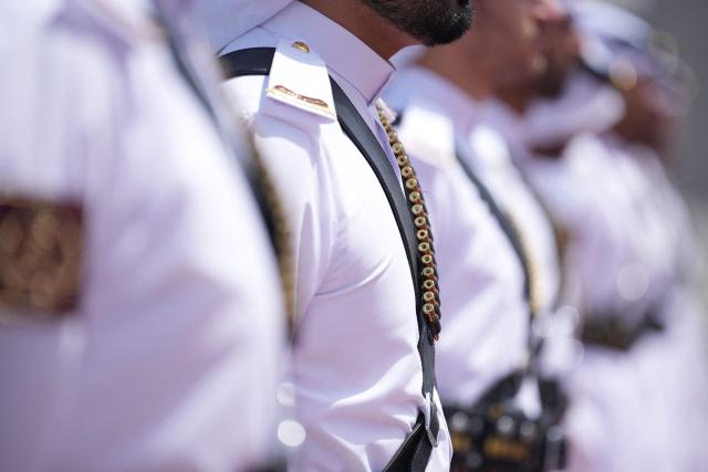 Soldiers of the honour guard wear bullet belts Britain's Prime Minister Keir Starmer boards his plane at the airport in Doha, Qatar on April 10, 2026. (Photo by Alastair Grant / POOL / AFP)