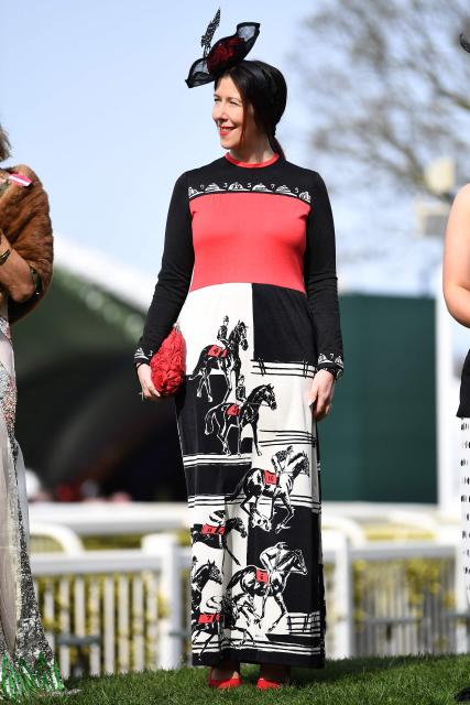 A racegoer smiles in the sunshine on Ladies Day, day two of the Grand National Festival horse race meeting at Aintree Racecourse in Liverpool, north-west England, on April 10, 2026. (Photo by PETER POWELL / AFP)