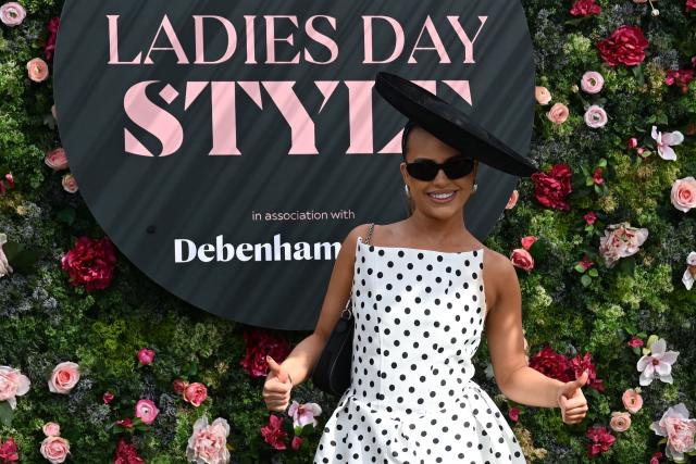 A racegoer poses for a picture on Ladies Day, day two of the Grand National Festival horse race meeting at Aintree Racecourse in Liverpool, north-west England, on April 10, 2026. (Photo by Paul ELLIS / AFP)