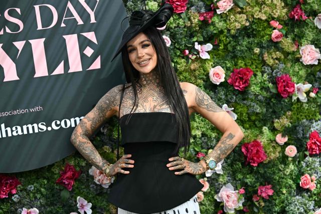 A racegoer poses for a picture on Ladies Day, day two of the Grand National Festival horse race meeting at Aintree Racecourse in Liverpool, north-west England, on April 10, 2026. (Photo by Paul ELLIS / AFP)