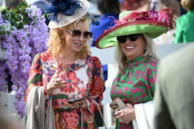 Racegoers smile on Ladies Day, day two of the Grand National Festival horse race meeting at Aintree Racecourse in Liverpool, north-west England, on April 10, 2026. (Photo by Paul ELLIS / AFP)