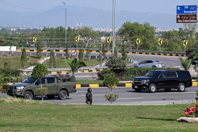 Pakistani troops (L) escort a motorcade vehicle carrying a US security officials as it makes its way toward the venue of the US–Iran talks in Islamabad on April 10, 2026. A cloud of uncertainty hung on April 10 over the scheduled start of talks in Pakistan between the United States and Iran, with no announcement yet on the arrival of negotiators and both sides accusing the other of failing to properly implement a fragile ceasefire. (Photo by Aamir QURESHI / AFP)