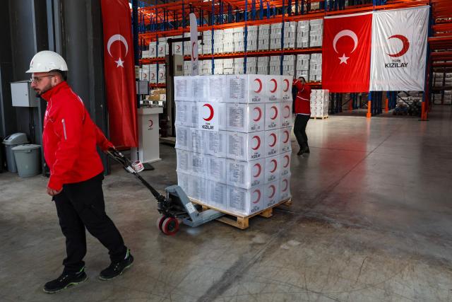 Workers handle aid cardboard boxes in Ankara on April 10, 2026 as The Red Cross and Turkey's Red Crescent plan to send supplies in Iran. The Red Cross and Turkey's Red Crescent on Friday dispatched an emergency humanitarian aid convoy from Turkey to Iran, as the organisation warned of a "desperate" humanitarian situation in the country. (Photo by Adem ALTAN / AFP)
