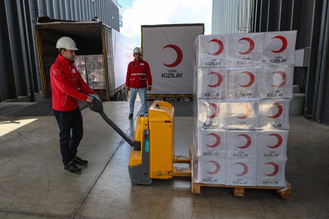 Workers handle aid cardboard boxes in Ankara on April 10, 2026 as The Red Cross and Turkey's Red Crescent plan to send supplies in Iran. The Red Cross and Turkey's Red Crescent on Friday dispatched an emergency humanitarian aid convoy from Turkey to Iran, as the organisation warned of a "desperate" humanitarian situation in the country. (Photo by Adem ALTAN / AFP)