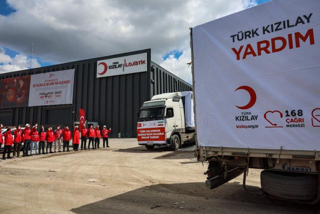 Workers wave as trucks of The Red Cross and Turkey's Red Crescent leaves to send supplies to Iran, in Ankara on April 10, 2026. The Red Cross and Turkey's Red Crescent on Friday dispatched an emergency humanitarian aid convoy from Turkey to Iran, as the organisation warned of a "desperate" humanitarian situation in the country. (Photo by Adem ALTAN / AFP)