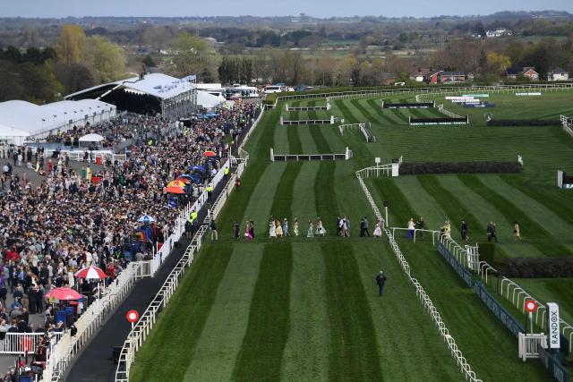 Racegoers cross the racecourse ahead of racing on day two of the Grand National Festival horse race meeting at Aintree Racecourse in Liverpool, north-west England, on April 10, 2026. (Photo by PETER POWELL / AFP)