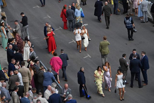 Racegoers mingle in front of the grandstand on Ladies Day, day two of the Grand National Festival horse race meeting at Aintree Racecourse in Liverpool, north-west England, on April 10, 2026. (Photo by PETER POWELL / AFP)