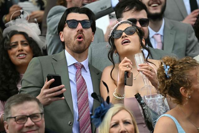 Racegoers react while watching the opening race on day two of the Grand National Festival horse race meeting at Aintree Racecourse in Liverpool, north-west England, on April 10, 2026. (Photo by Paul ELLIS / AFP)