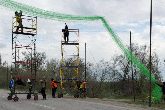 Ukrainian servicemen cover the road with a net to protect vehicles from drone attacks at an undisclosed location in the Zaporizhzhia region on April 10, 2026, amid the Russian invasion of Ukraine. (Photo by Darya NAZAROVA / AFP)