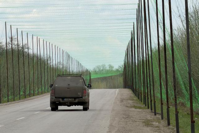 A car drives along a road covered with a net protecting from drone attacks at an undisclosed location in the Zaporizhzhia region on April 10, 2026, amid the Russian invasion of Ukraine. (Photo by Darya NAZAROVA / AFP)