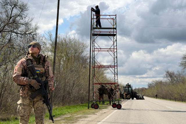 Ukrainian servicemen cover the road with a net to protect vehicles from drone attacks at an undisclosed location in the Zaporizhzhia region on April 10, 2026, amid the Russian invasion of Ukraine. (Photo by Darya NAZAROVA / AFP)