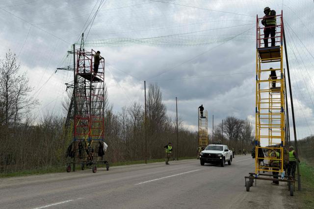 Ukrainian servicemen cover the road with a net to protect vehicles from drone attacks at an undisclosed location in the Zaporizhzhia region on April 10, 2026, amid the Russian invasion of Ukraine. (Photo by Darya NAZAROVA / AFP)