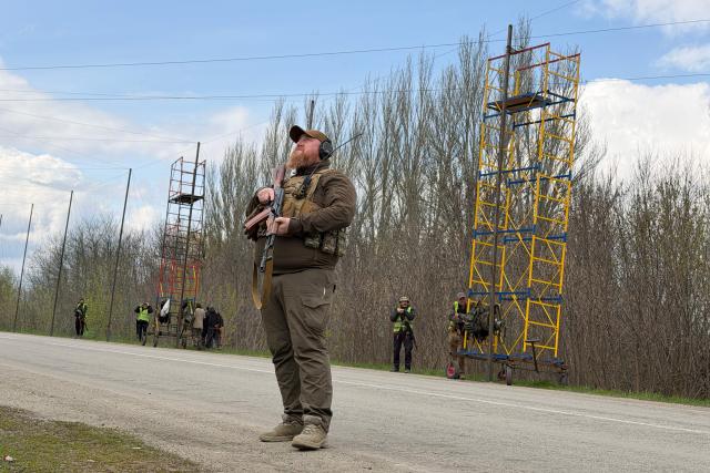 Ukrainian servicemen cover the road with a net to protect vehicles from drone attacks at an undisclosed location in the Zaporizhzhia region on April 10, 2026, amid the Russian invasion of Ukraine. (Photo by Darya NAZAROVA / AFP)