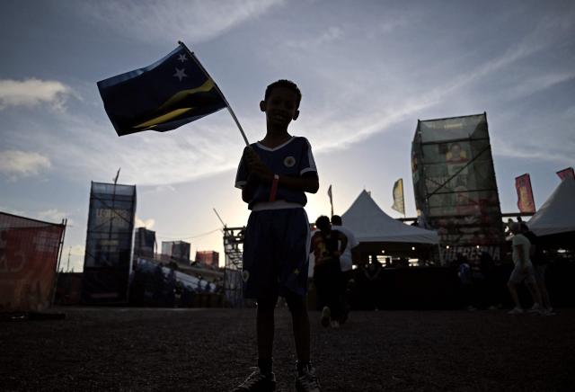 A boy holds a Curacao flag during the Legends Football Tournament  in Willemstad, Curacao, in the Dutch Caribbean, on April 9, 2026. (Photo by Raul ARBOLEDA / AFP)