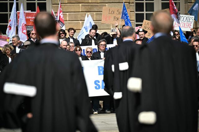Lawyers take part in a gathering in front of the Parlement of Brittany building as part of a national strike against a bill on criminal justice and respect for victims, in Rennes, western France, on April 10, 2026. (Photo by Lou BENOIST / AFP)