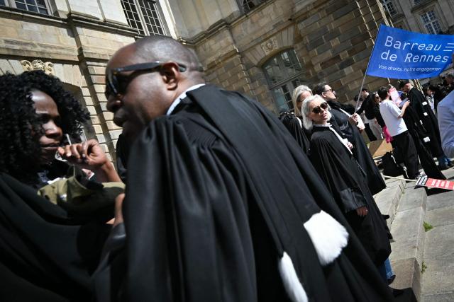 Lawyers take part in a gathering in front of the Parlement of Brittany building as part of a national strike against a bill on criminal justice and respect for victims, in Rennes, western France, on April 10, 2026. (Photo by Lou BENOIST / AFP)