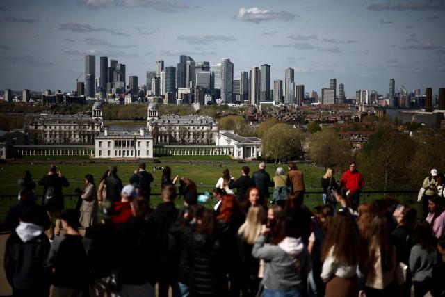 People look on at the Old Royal Naval College from Greenwich Park in south-east London on April 10, 2026. (Photo by Henry NICHOLLS / AFP)