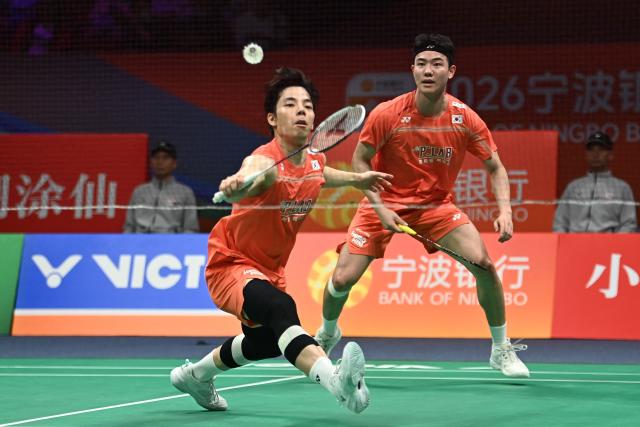 Ki Dong Ju (L) and Kang Min Hyuk (R) of South Korea hit a return to Soh Wooi Yik and Aaron Chia of Malaysia during their men's doubles quarter-final match at the Badminton Asia Championship in Ningbo, eastern China's Zhejiang province on April 10, 2026. (Photo by CN-STR / AFP) / China OUT
