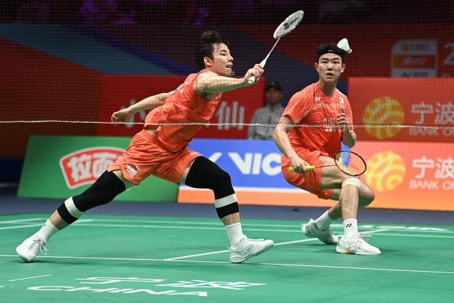 Ki Dong Ju (L) and Kang Min Hyuk (R) of South Korea hit a return to Soh Wooi Yik and Aaron Chia of Malaysia during their men's doubles quarter-final match at the Badminton Asia Championship in Ningbo, eastern China's Zhejiang province on April 10, 2026. (Photo by CN-STR / AFP) / China OUT