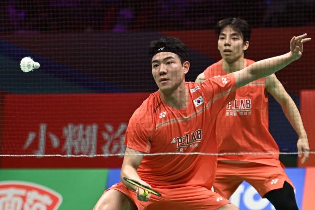 Ki Dong Ju (back) and Kang Min Hyuk (front) of South Korea hit a return to Soh Wooi Yik and Aaron Chia of Malaysia during their men's doubles quarterfinal match at the Badminton Asia Championship in Ningbo, eastern China's Zhejiang province on April 10, 2026. (Photo by CN-STR / AFP) / China OUT