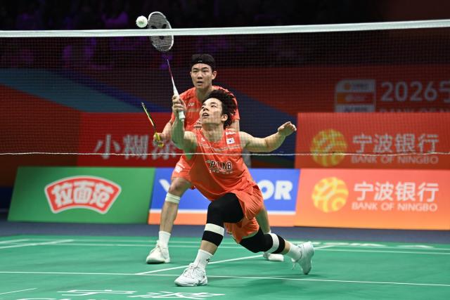 Ki Dong Ju (front) and Kang Min Hyuk (back) of South Korea hit a return to Soh Wooi Yik and Aaron Chia of Malaysia during their men's doubles quarter-final match at the Badminton Asia Championship in Ningbo, eastern China's Zhejiang province on April 10, 2026. (Photo by CN-STR / AFP) / China OUT