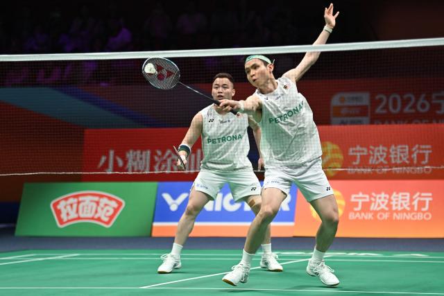 Soh Wooi Yik (front) and Aaron Chia (back) of Malaysia hit a return to Ki Dong Ju and Kang Min Hyuk of South Korea during their men's doubles quarter-final match at the Badminton Asia Championship in Ningbo, eastern China's Zhejiang province on April 10, 2026. (Photo by CN-STR / AFP) / China OUT