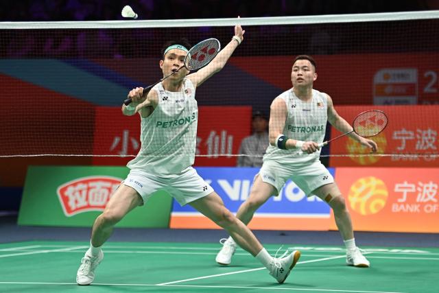 Soh Wooi Yik (front) and Aaron Chia (back) of Malaysia hit a return to Ki Dong Ju and Kang Min Hyuk of South Korea during their men's doubles quarter-final match at the Badminton Asia Championship in Ningbo, eastern China's Zhejiang province on April 10, 2026. (Photo by CN-STR / AFP) / China OUT