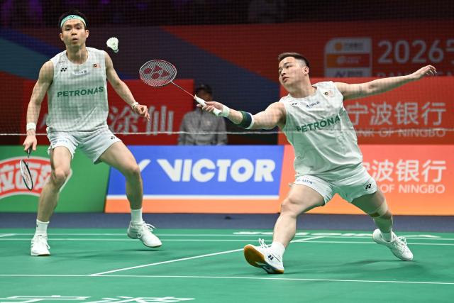 Soh Wooi Yik (L) and Aaron Chia (R) of Malaysia hit a return to Ki Dong Ju and Kang Min Hyuk of South Korea during their men's doubles quarter-final match at the Badminton Asia Championship in Ningbo, eastern China's Zhejiang province on April 10, 2026. (Photo by CN-STR / AFP) / China OUT