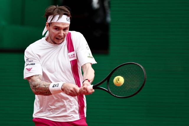Kazakhstan's Alexander Bublik hits a backhand return to Spain's Carlos Alcaraz during the Monte Carlo ATP Masters Series Tournament quarter final tennis match on Court Rainier III at the Monte-Carlo Country Club in Roquebrune-Cap-Martin, south-eastern France on April 10, 2026. (Photo by Thibaud MORITZ / AFP)