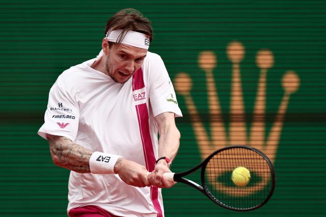 Kazakhstan's Alexander Bublik plays a backhand return to Spain's Carlos Alcaraz during the Monte Carlo ATP Masters Series Tournament quarter final tennis match on Court Rainier III at the Monte-Carlo Country Club in Roquebrune-Cap-Martin, south-eastern France on April 10, 2026. (Photo by Thibaud MORITZ / AFP)