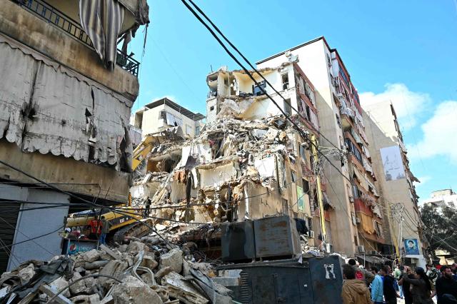 This photograph taken on April 10, 2026, during a media tour organized by Hezbollah’s media office shows a digger clearing the rubble of a building in Beirut's Hay al-Selloum neighbourhood, that was targetted in an Israeli strike earlier this week. The Israeli military said on April 10 that it had "dismantled" more than 4,300 Hezbollah sites in Lebanon since fighting with the militant group began last month. (Photo by FADEL itani / AFP) / 