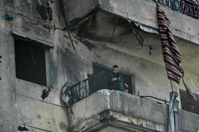 This photograph taken on April 10, 2026, during a media tour organized by Hezbollah’s media office shows a man standing on the balcony of a damaged building at southern Beirut's Chweifat-Amrousiyeh neighbourhood that was targetted in an Israeli strike earlier this week. The Israeli military said on April 10 that it had "dismantled" more than 4,300 Hezbollah sites in Lebanon since fighting with the militant group began last month. (Photo by FADEL itani / AFP) / 