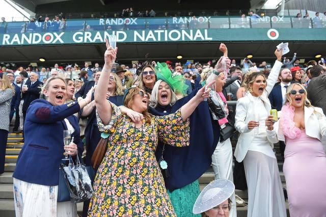 Racegoers react to the finish of the Melling Chase on day two of the Grand National Festival horse race meeting at Aintree Racecourse in Liverpool, north-west England, on April 10, 2026. (Photo by PETER POWELL / AFP)