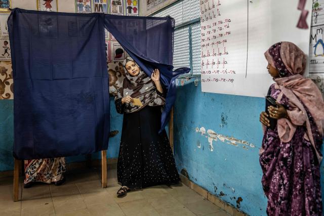 A voter leaves a voting booth before casting her ballot at a primary school serving as a polling station in Djibouti, on April 10, 2026, during the 2026 Djiboutian presidential elections. (Photo by Luis TATO / AFP)