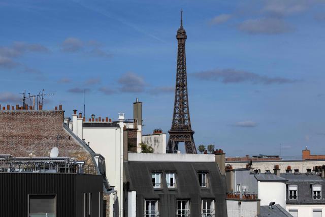 A photo shows the Eiffel Tower seen form behind rooftops in Paris on April 10, 2026. (Photo by JOEL SAGET / AFP)