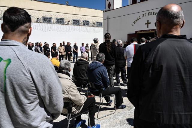 Inmates attend a church service following the Epitafios procession at the Church of Agios Eleftherios inside the Grevena prison, on April 10, 2026. Millions of worshippers flock to churches all week long to celebrate Easter, the foremost celebration in Orthodox faith. (Photo by Sakis Mitrolidis / AFP)