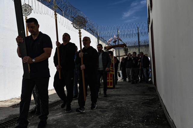 Inmates attend a church service following the Epitafios procession at the Church of Agios Eleftherios inside the Grevena prison, on April 10, 2026. Millions of worshippers flock to churches all week long to celebrate Easter, the foremost celebration in Orthodox faith. (Photo by Sakis Mitrolidis / AFP)