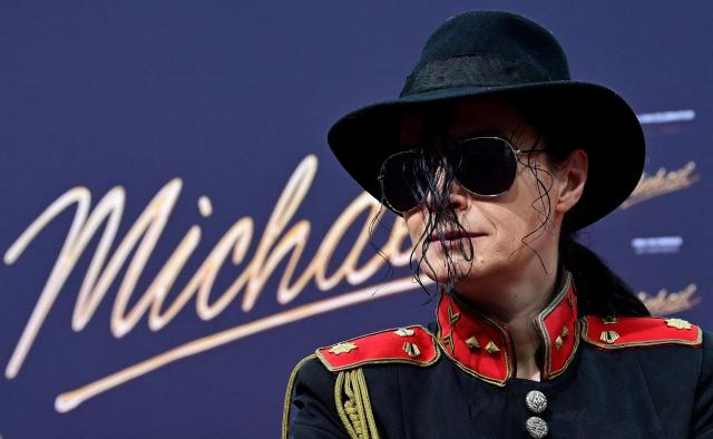 A Michael Jackson look-alike poses for photogaphers on the red carptet for the world premiere of the Michael Jackson biopic "Michael" at the Uber Eats Music Hall in Berlin on April 10, 2026. Thousands of Michael Jackson fans converged on April 10, 2026 to Berlin before the world premiere of the biopic on the king of pop, despite the accusations of paedophilia that still target the artist. (Photo by John MACDOUGALL / AFP) / ALTERNATIVE CROP