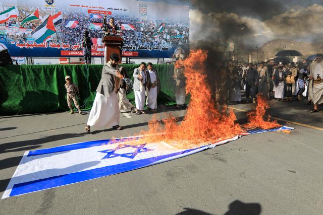 Supporters of the Iran-backed Houthi movement set fire to Israeli and US national flags as they rally in solidarity with Iran and Lebanon in the Yemeni capital Sanaa on April 10, 2026. Pakistan was poised on April 10, to host Iranian and US delegations for negotiations in its capital, although Tehran's participation remained uncertain after deadly Israeli strikes on Lebanon threatened this week's temporary truce. (Photo by Mohammed HUWAIS / AFP)