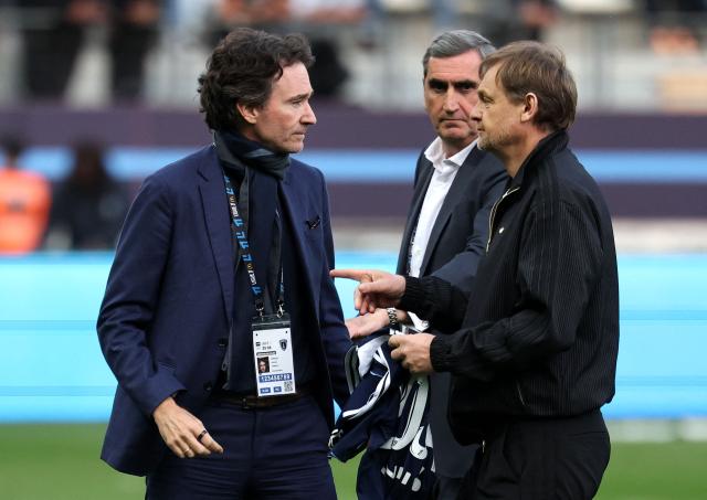French representative of the Agache family holding company, Antoine Arnault (L) speaks with Chief Executive Officer of German sportswear giant Adidas, Bjoern Gulden during the French L1 football match between Paris FC and AS Monaco at the Stade Jean-Bouin in Paris on April 10, 2026. (Photo by FRANCK FIFE / AFP)