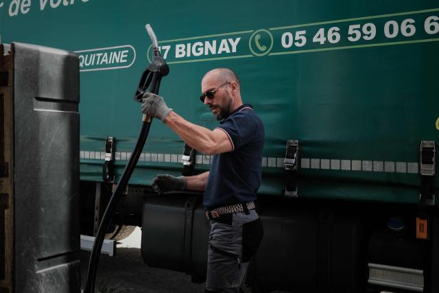 (FILES) A road haulage company employee fuels a truck at a depot in Bignay, south-western France, on March 31, 2026, as French truckers face mounting pressure from rising diesel prices. The increase in fuel prices due to the situation in the Middle East has led to a surge in fuel theft from truckers’ tanks. (Photo by Philippe LOPEZ / AFP)