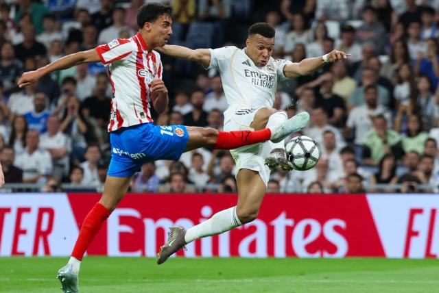 Real Madrid's French forward #10 Kylian Mbappe (R) is challenged by Girona's Brazilian defender #12 Vitor Reis during the Spanish league football match between Real Madrid CF and Girona FC at the Santiago Bernabeu stadium in Madrid on April 10, 2026. (Photo by Thomas COEX / AFP)