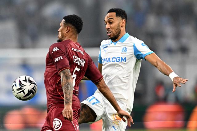 Metz's Ivorian midfielder #05 Jean-Philippe Gbamin vies with Marseille's Gabonese forward #17 Pierre-Emerick Aubameyang (R) during the French L1 football match between Olympique de Marseille (OM) and Metz FC at the Stade Velodrome in Marseille, southern France on April 10, 2026. (Photo by Gabriel BOUYS / AFP)