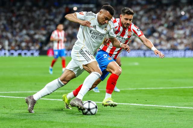 Real Madrid's French forward #10 Kylian Mbappe (L) is challenged by Girona's Spanish defender #24 Alexandre Moreno during the Spanish league football match between Real Madrid CF and Girona FC at the Santiago Bernabeu stadium in Madrid on April 10, 2026. (Photo by Thomas COEX / AFP)