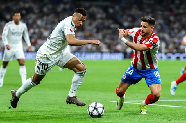 Real Madrid's French forward #10 Kylian Mbappe (L) is challenged by Girona's Spanish defender #24 Alexandre Moreno during the Spanish league football match between Real Madrid CF and Girona FC at the Santiago Bernabeu stadium in Madrid on April 10, 2026. (Photo by Thomas COEX / AFP)